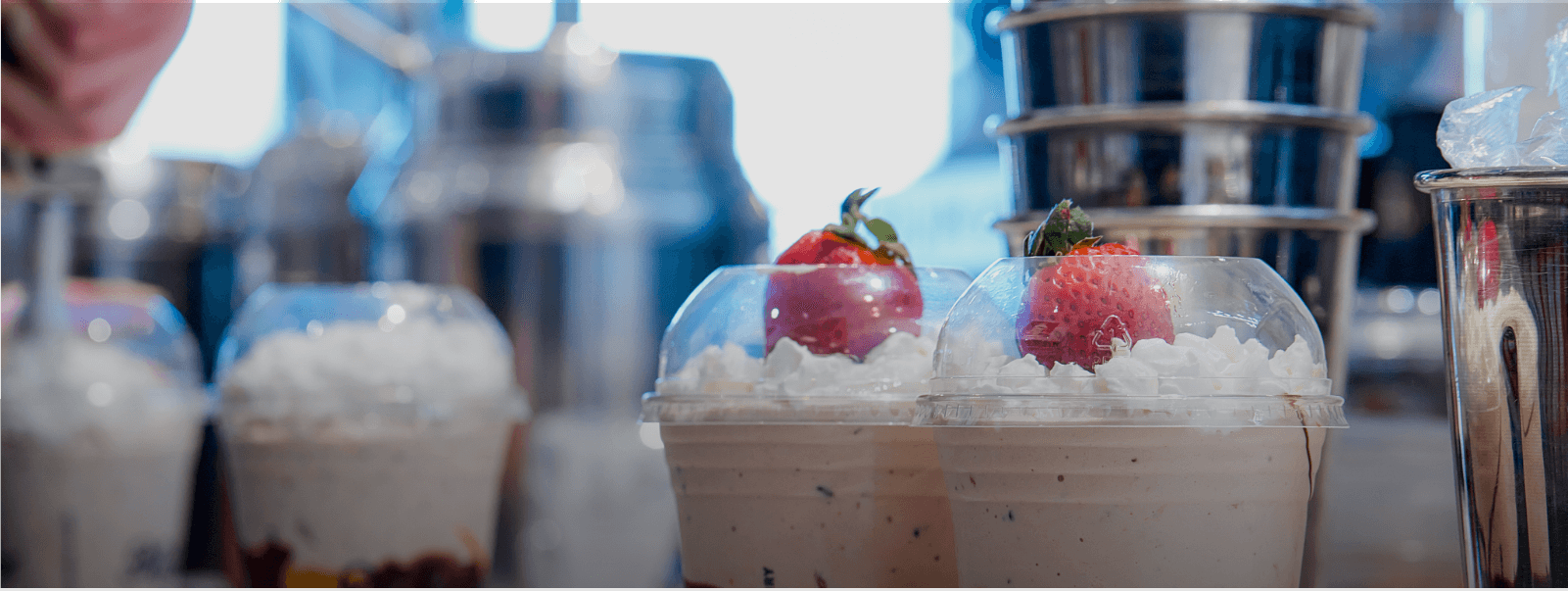 two milkshakes with strawberries on top