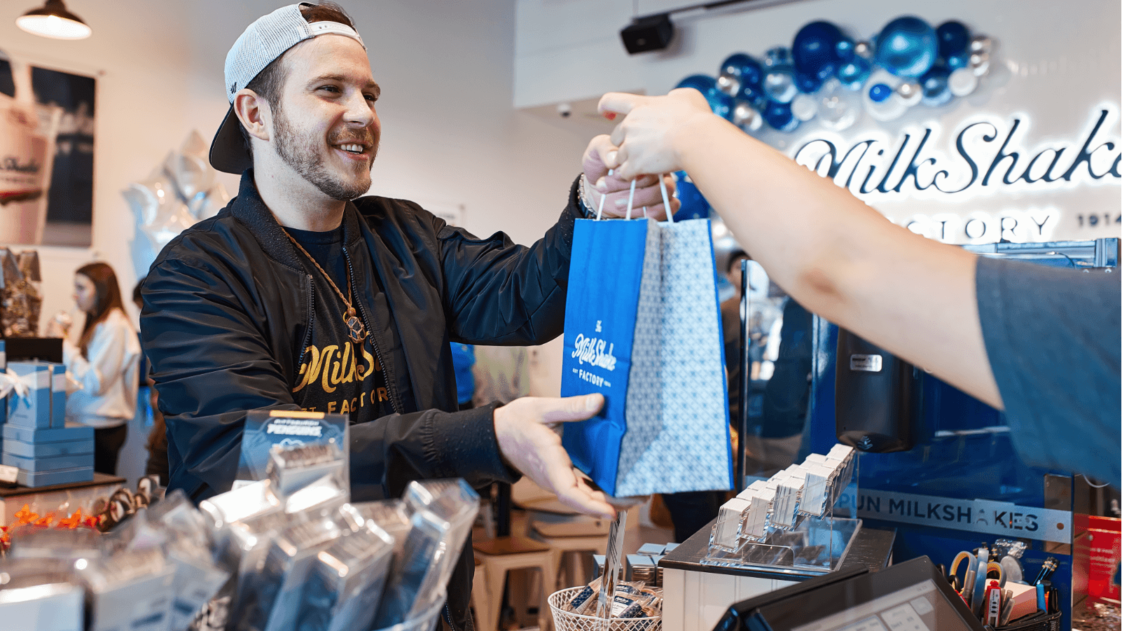 milkshake factory employee handing customer bag