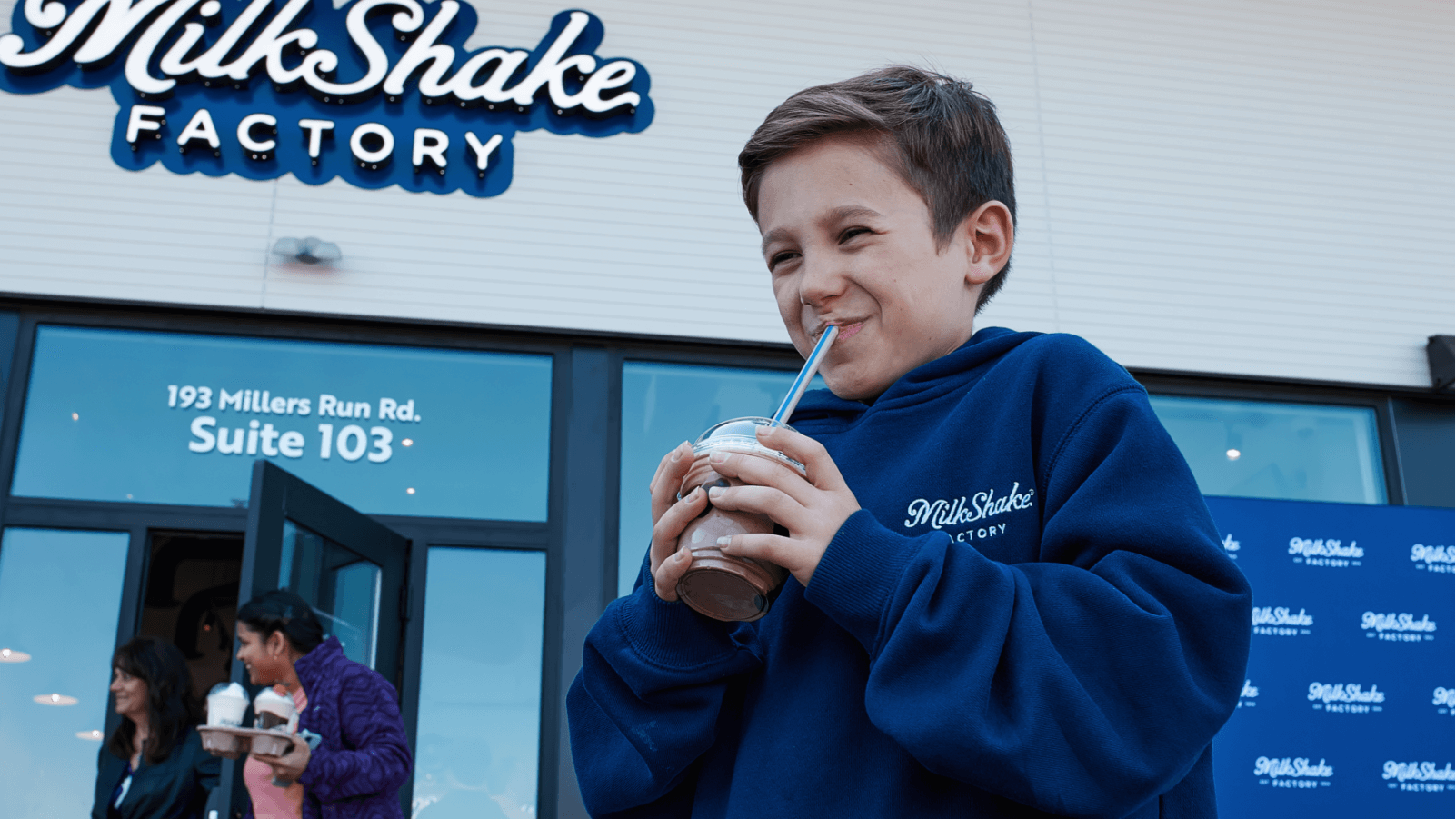 child drinking milkshake outside of store