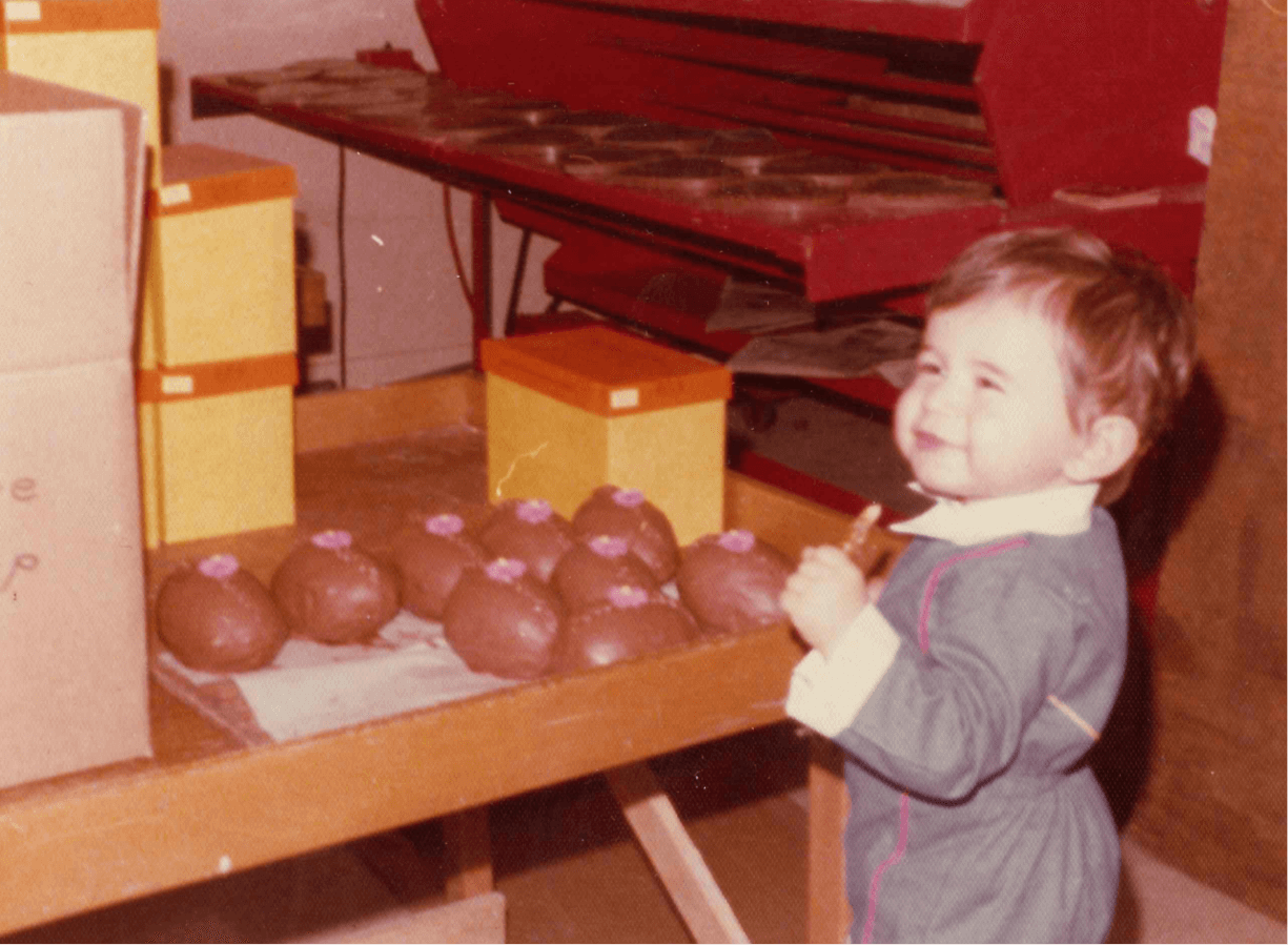 little boy standing at table with chocolate eggs